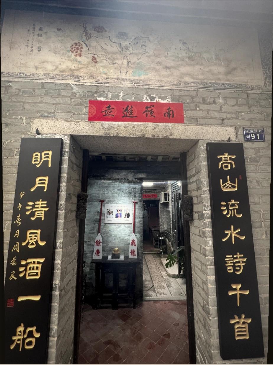 青砖老宅的入口与黑底金字对联